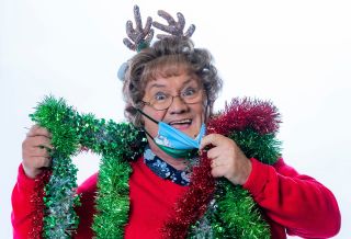 Mrs Brown draped in tinsel and wearing a face mask