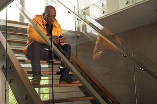 Lennie James sits on a staircase