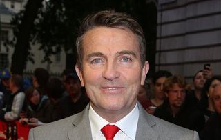 Bradley Walsh wearing a light suit and red tie at a film premier. 