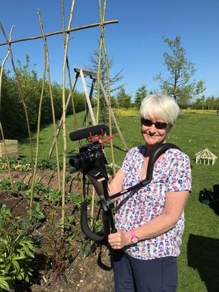 Lights, camera, Alison! Alan Titchmarsh's wife holding camera in garden