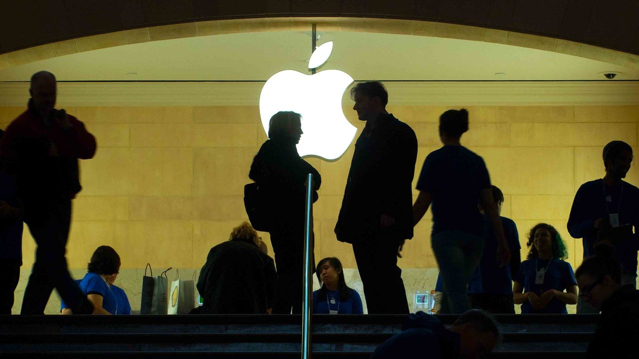 Apple stock logo shown as people stand outside of Apple store