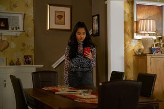 Coronation Street spoilers: Asha Alahan looks at the picture on her phone in horror