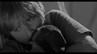 The scared young boy in the music video is seen hiding away from his violent home life (credit: Three Wise Monkeys)