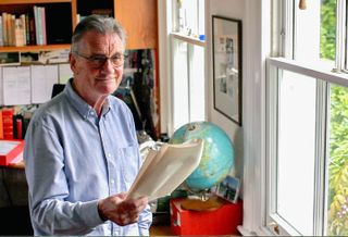 Michael Palin poses with a globe for his new BBC2 series Michael Palin's Travels