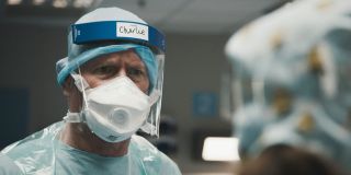 Casualty's Charlie in full PPE talking with Connie