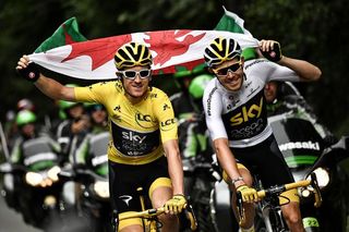 Geraint Thomas wearing the overall leader's yellow jersey and teammate Luke Rowe hold the Welsh flag as they ride during the 21st and last stage of the 105th edition of the Tour de France