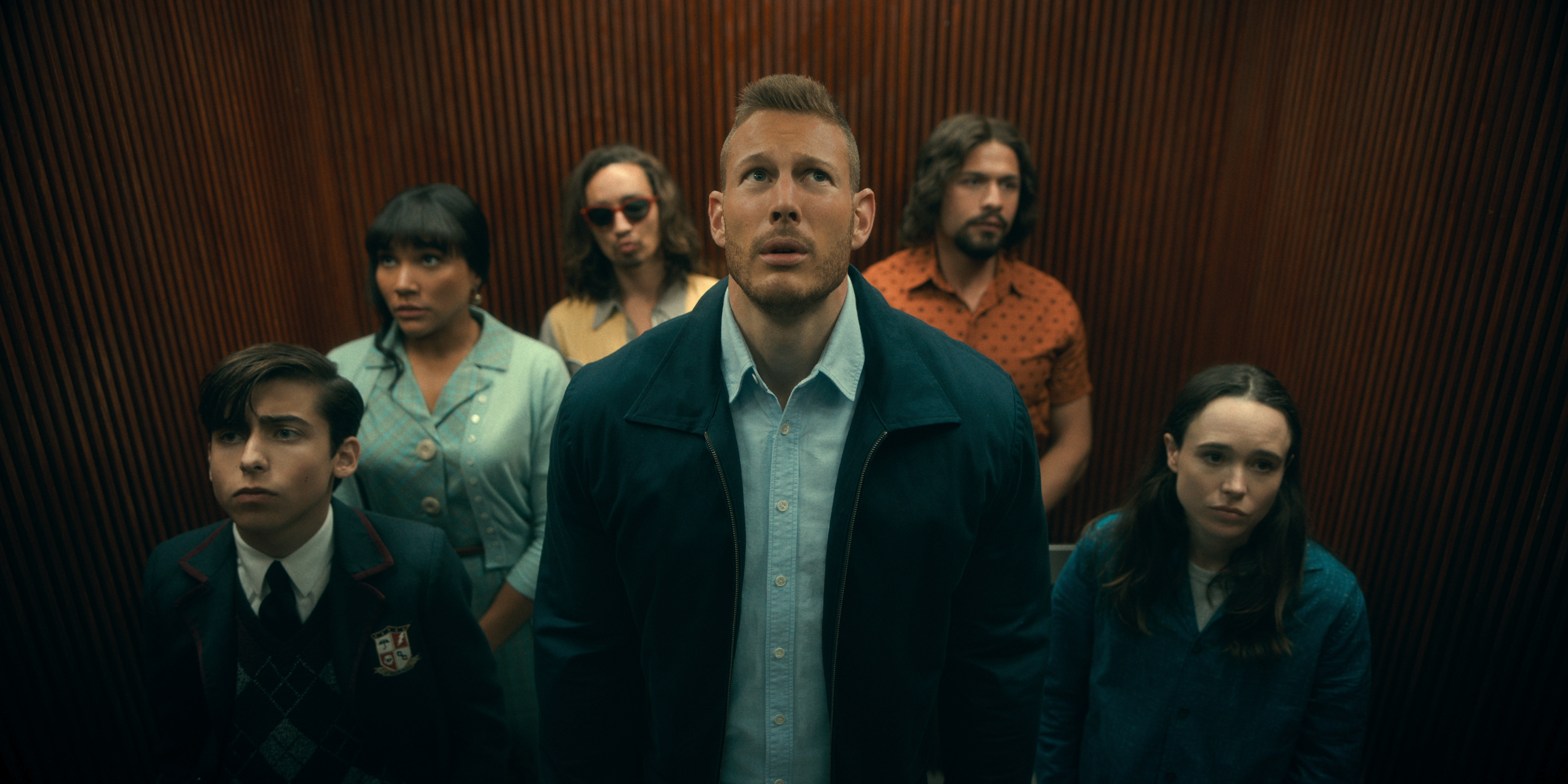 Aiden Gallagher, Emmy Raver-Lampman, Robert Sheehan, Tom Hopper, David Castañeda and Ellen Page gather in a lift in The Umbrella Academy series two